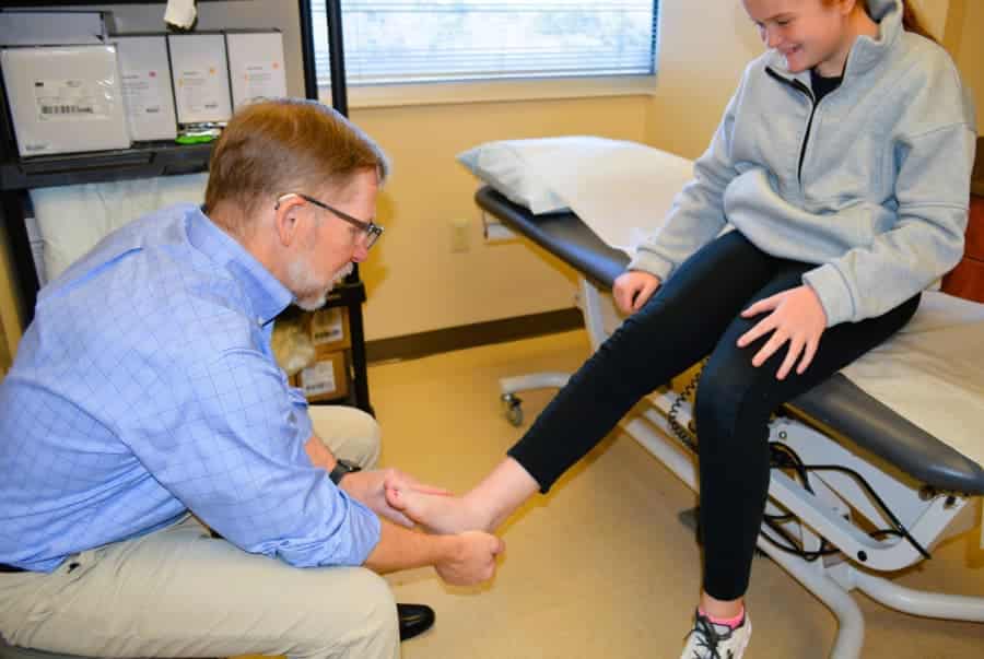 Dr. Kirchner examining girl's foot for an achilles tendon injury
