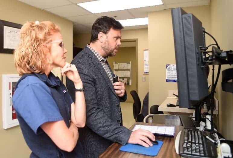 Dr. William S. Craig and team member looking at computer screen in medical office