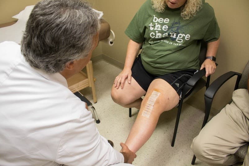 Dr. Michael F. Blum examining patient’s knee after knee surgery