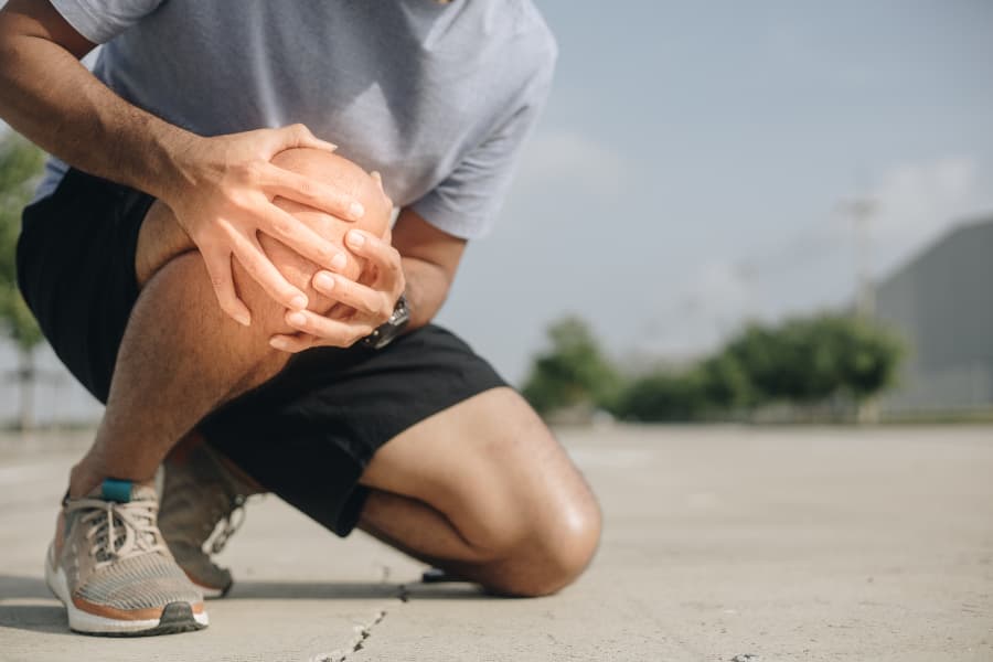 Runner suffering from knee pain outdoors