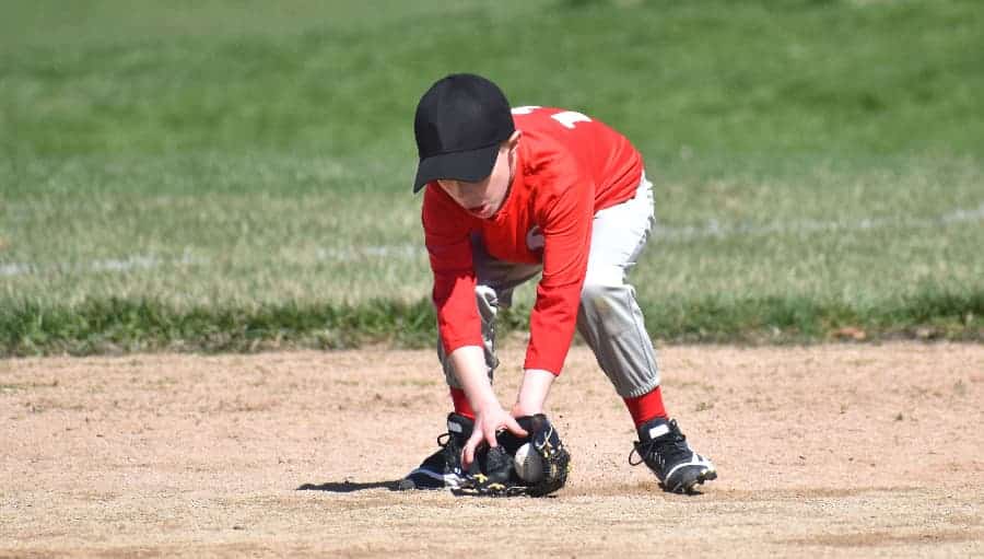 Teen baseball player fielding a ground ball