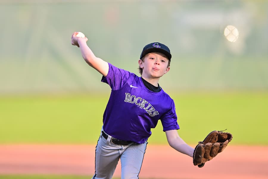 Youth baseball player throwing baseball