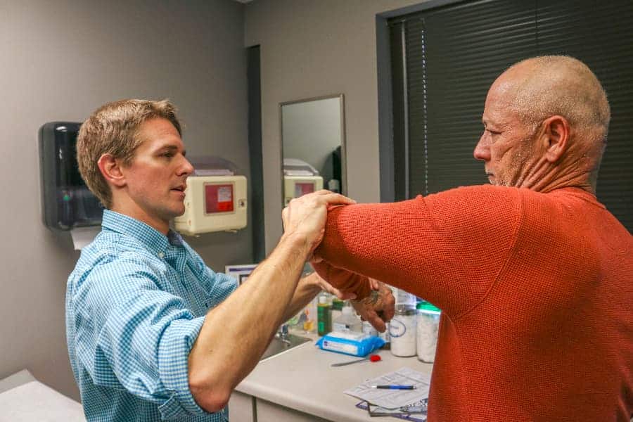 Dr. Michael Smith examing patient for golfer’s elbow
