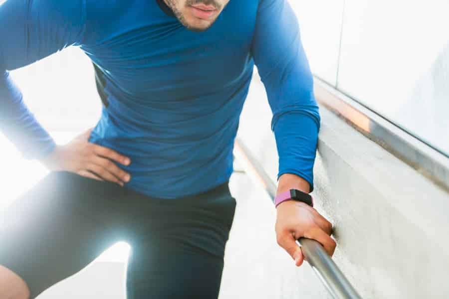 Young athlete with hip pain grabbing onto metal bar