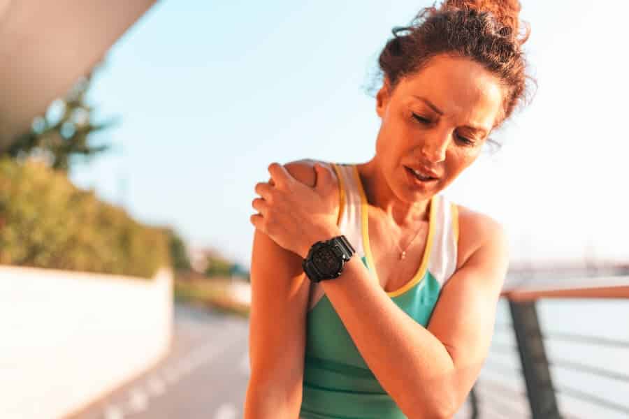 Athletic person holding shoulder in pain