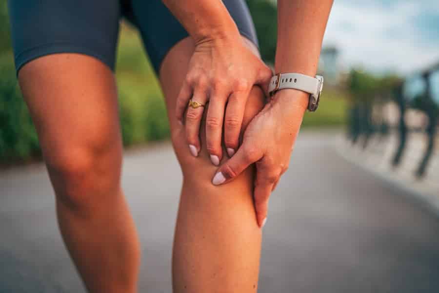 Runner experiencing knee pain after exercising outdoors